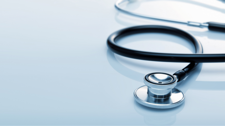 Close-up of medical stethoscope on reflective blue surface
