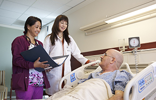 A physician and nurse speaking to a patient