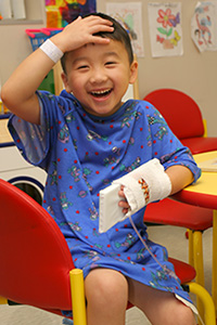 A child hugging a patient therapy pet while two physicians look on.