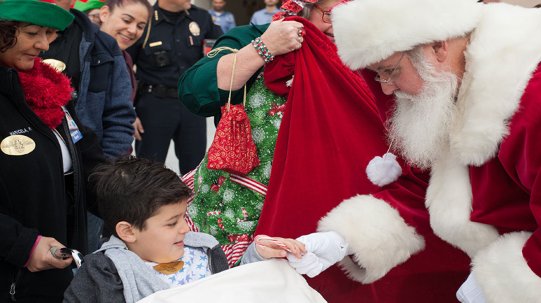Santa Claus giving a candy cane to a young child