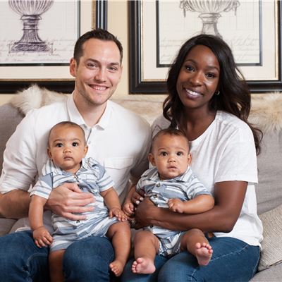 Elizabeth Lascaze Smith and her husband, sitting on a couch and holding their twin children