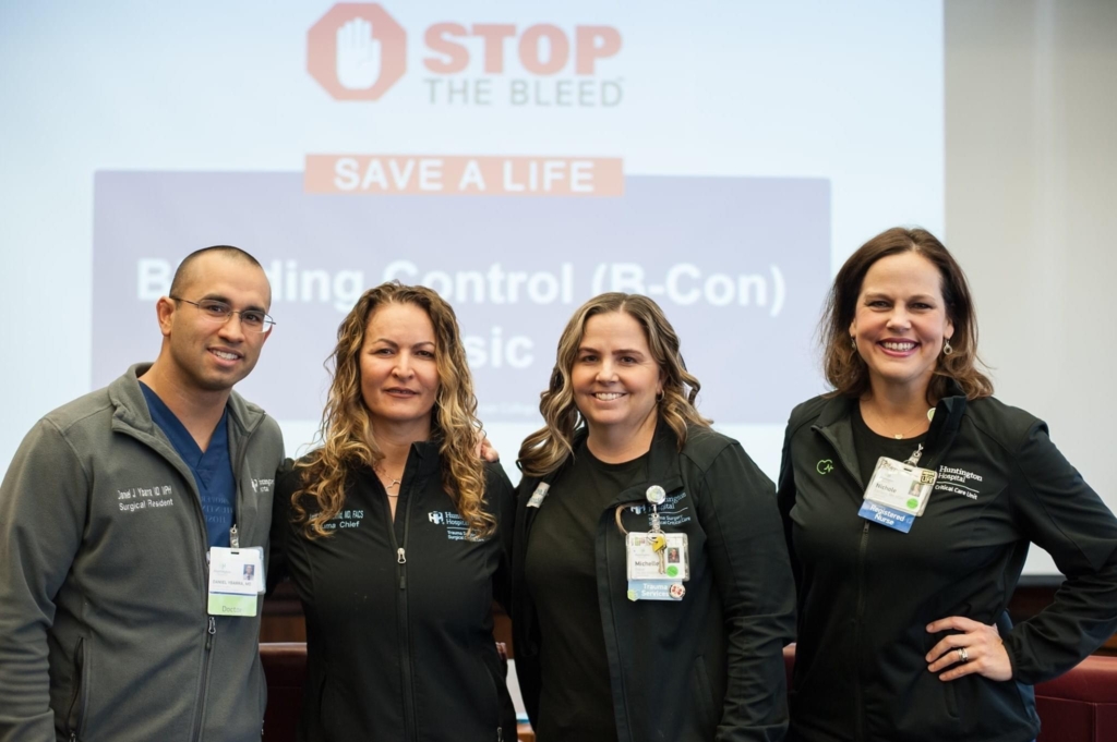 A group of four residents in front of a Stop The Bleed slide