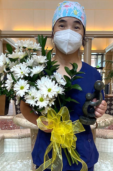 Hui Juan Qin Lilly holding the Daisy award