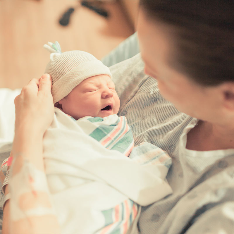 Woman holding a new born baby, wrapped in a blanket