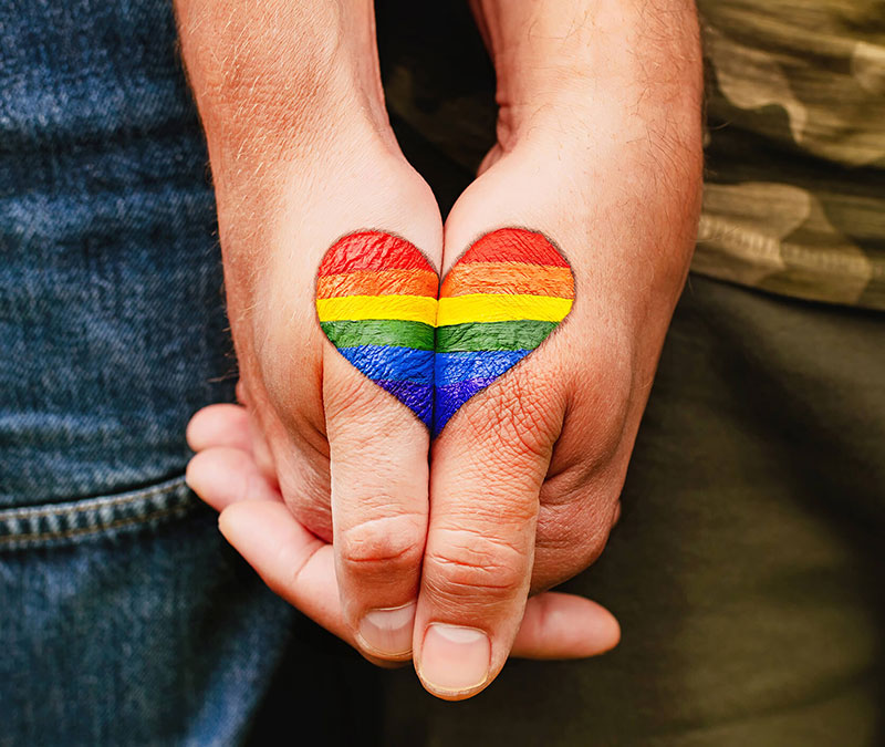 Two hands holding each other, two halves of a heart forming a single one.