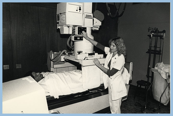 Black and white photo from 1980 of a man in an MRI machine with a woman nurse