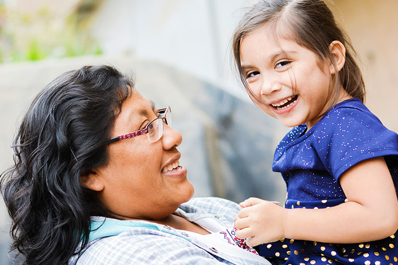 Latina mother and smiling daughter