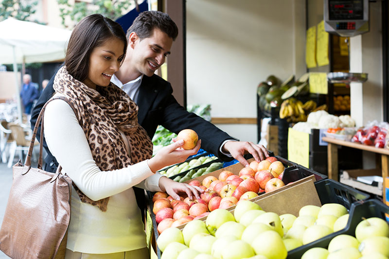 Happy couple shops for fruit at the market