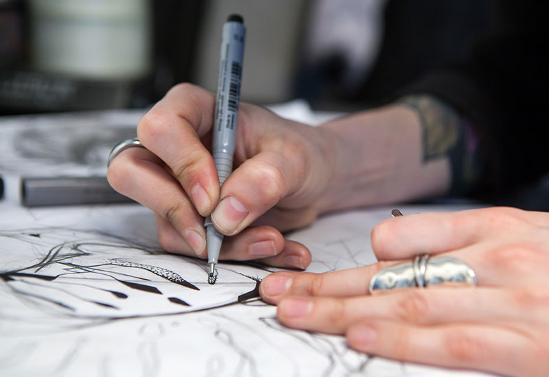 Woman drawing on paper with pen
