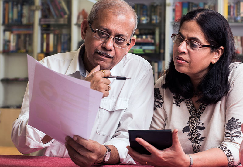 Senior indian couple looking at paperwork together