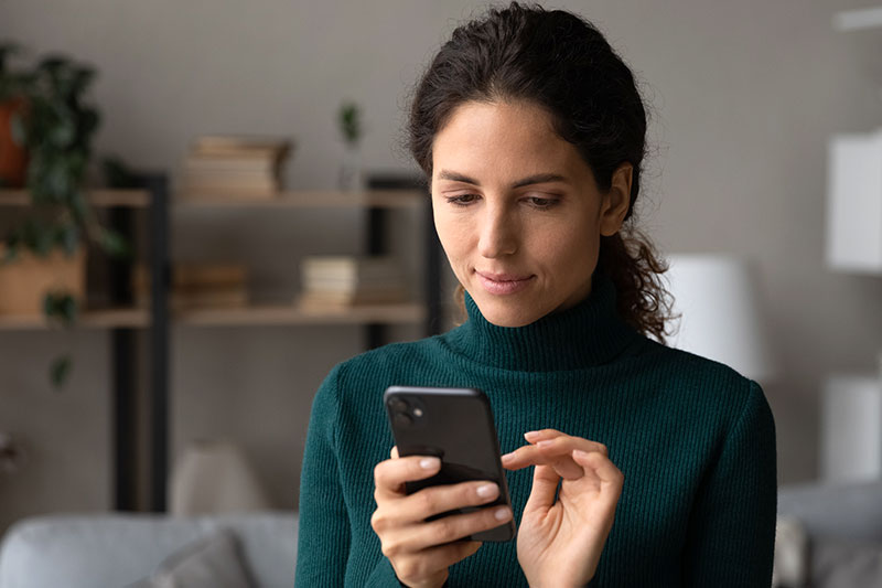Woman holding a cellphone and navigating a website with her finger