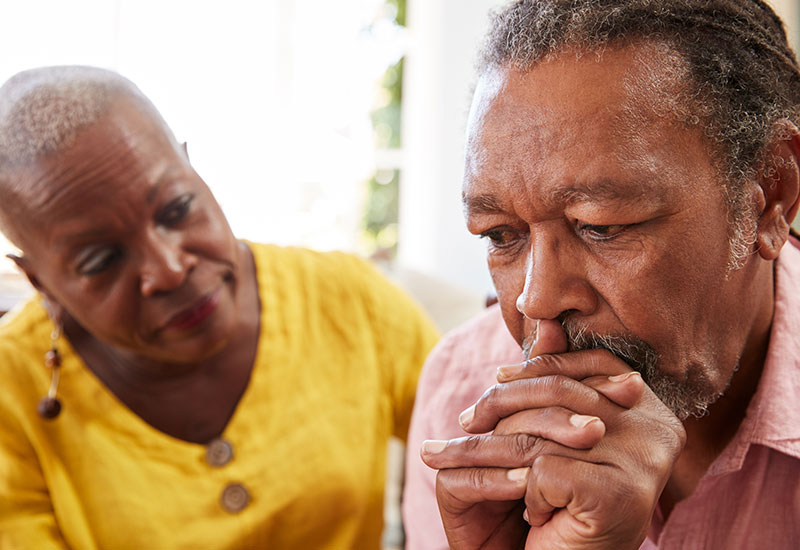 Senior woman comforting a senior man who looks upset