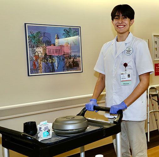 Huntington Hospital volunteer, delivering food on a cart