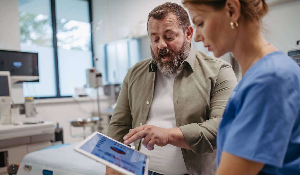 nurse and patient pointing at a tablet