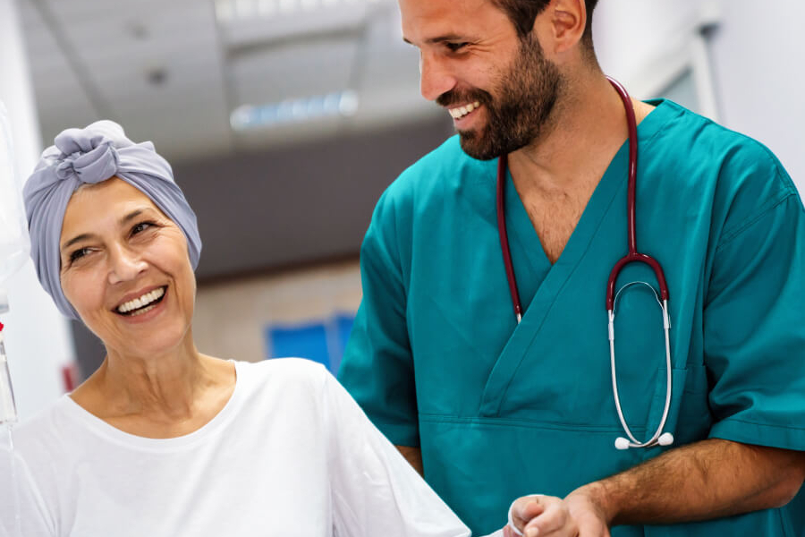 male nurse helping woman with head wrap walk