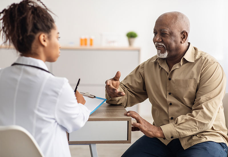 female doctor talking to senior patient