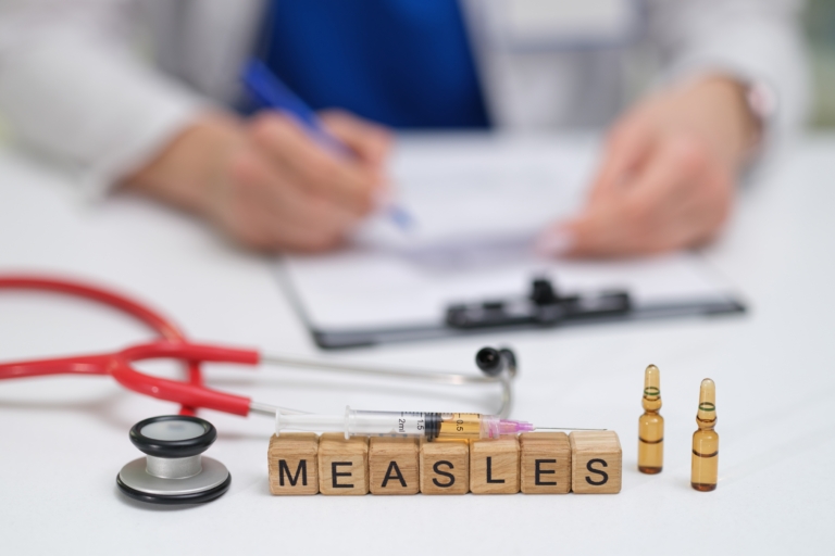 A,Doctor,Carefully,Documents,The,Measles,Vaccination,Process,,Noting,The
