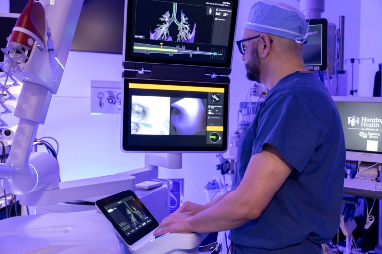 Surgeon operating robotic medical equipment during a procedure.