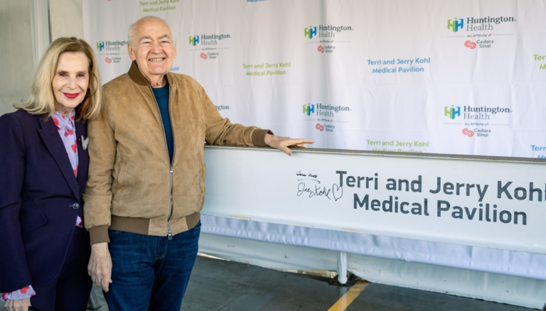 Terri and Jerry Kohl posing beside signed Medical Pavilion steel beam